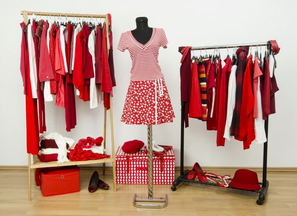 کمد لباس با لباس های قرمز و سفید چیده شده روی چوب لباسی و لباس روی مانکن کمد لباس پر از تمام سایه های قرمز لباس کفش و لوازم جانبی