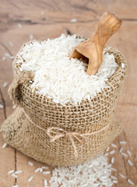 برنج در یک کیسه گونی روی سطح چوبی