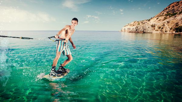 Wakeboarder سوار بر تخته در دریا در روز آفتابی Wakeboarding در ساحل