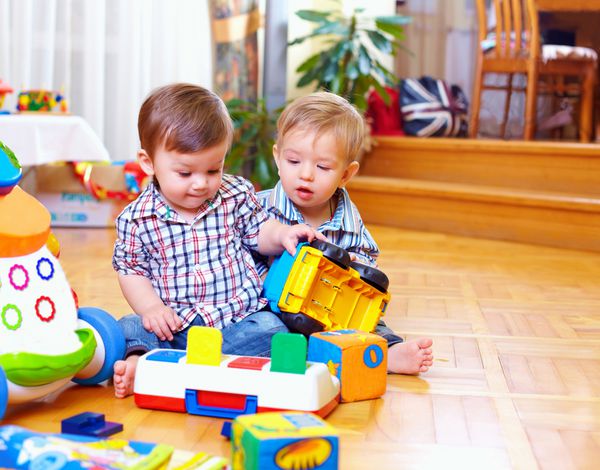 دو کودک نوپا ناز در حال بازی در اتاق مهد کودک
