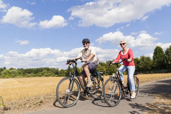 زوج سالخورده ای که از سفر با دوچرخه لذت می برند