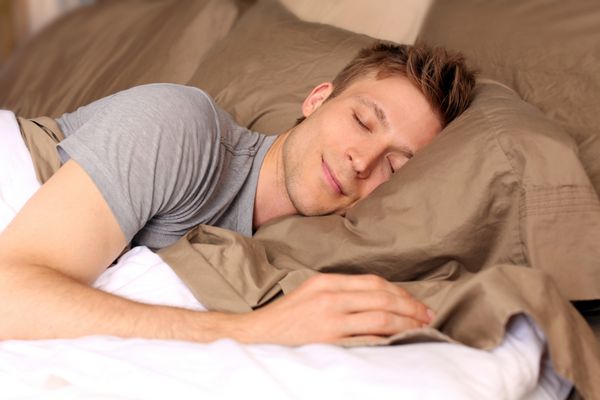 مرد جوانی که راحت در تختش می خوابد