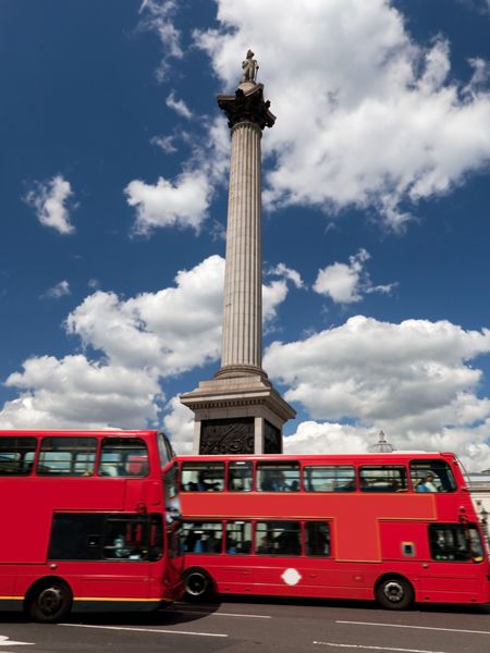 میدان ترافالگار در لندن انگلستان اتوبوس های قرمز در حال حرکت