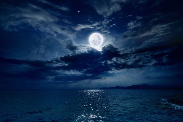 آسمان شب با ماه کامل و انعکاس در دریا ستاره ها ابرهای زیبا عناصر این تصویر توسط ناسا ارائه شده است