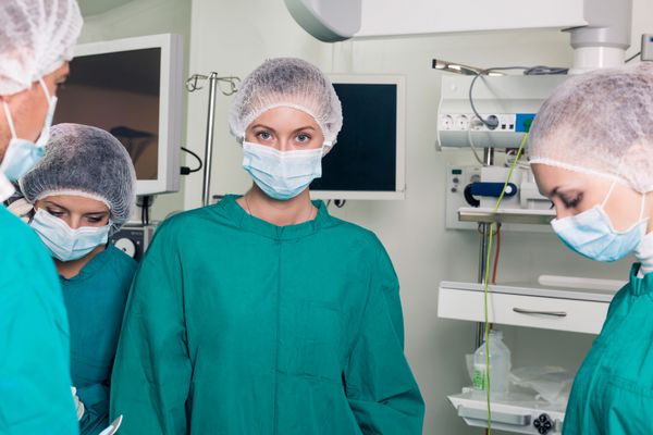جراح با همکارانش به دوربین نگاه می کند