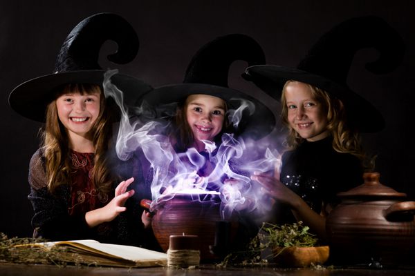 سه جادوگر کوچک هالووین در حال خواندن طلسم بالای گلدان