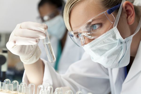تیم تحقیقات علمی زن با محلول شفاف در آزمایشگاه