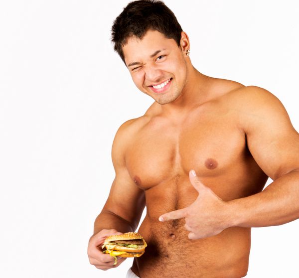 مرد جوان عضلانی که یک همبرگر در دست دارد