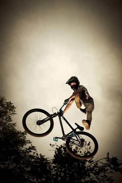 مرد جوانی که با دوچرخه خود پرواز می کند پرش خاک