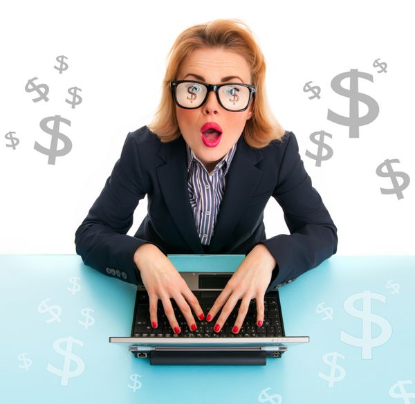 زن تجاری متعجب در حال گشت و گذار در لپ تاپ علائم دلار در اطراف