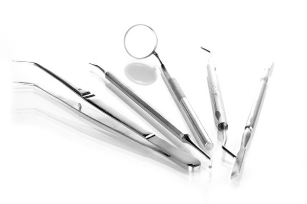 مجموعه ای از ابزارهای دندانپزشکی برای مراقبت از دندان جدا شده بر روی سفید