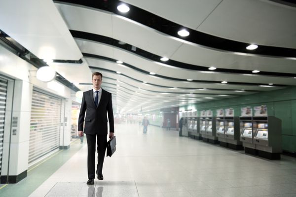 مرد تاجر در حال قدم زدن در مترو
