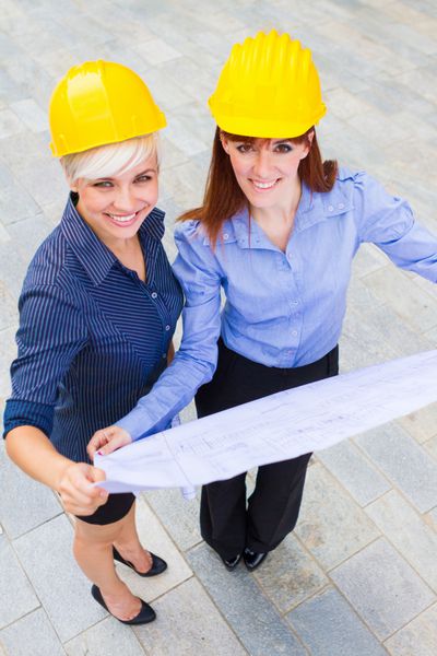 سازنده های زن که پروژه را در دستان خود در حالی که لبخند می زنند