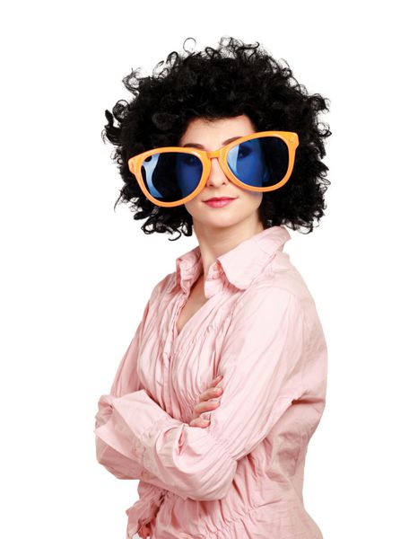 زن جوانی که کلاه گیس افرو و عینک بزرگ به سر دارد