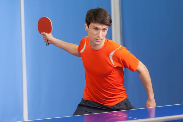 بازیکن تنیس روی میز مردان جوان با اعتماد به نفس در حال بازی تنیس روی میز