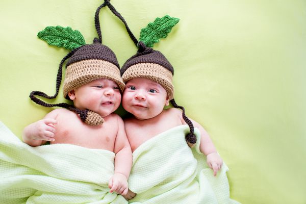 دو نوزاد برادر دوقلو که کلاه بلوط پوشیده بودند