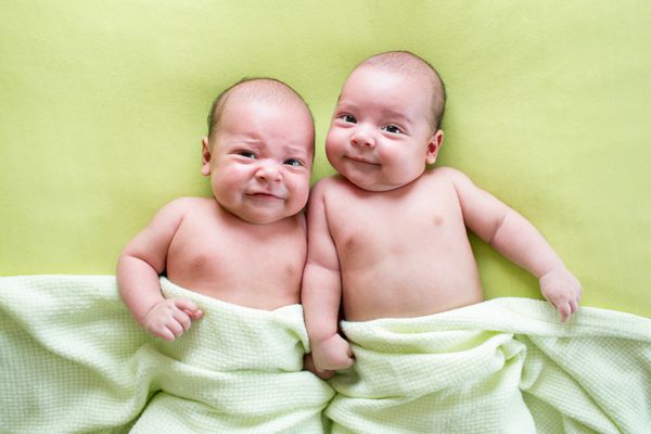 دوقلوهای خنده دار برادران نوزادان دراز کشیدن روی سبز