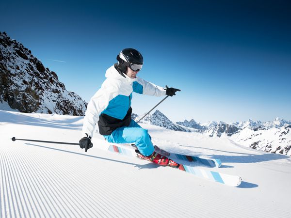 اسکی باز در کوه پیست آماده و روز آفتابی