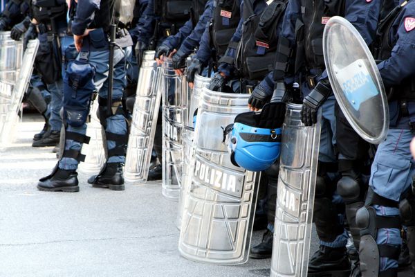 پلیس در لباس ضد شورش با سپر و کلاه و کلاه ایمنی دوری
