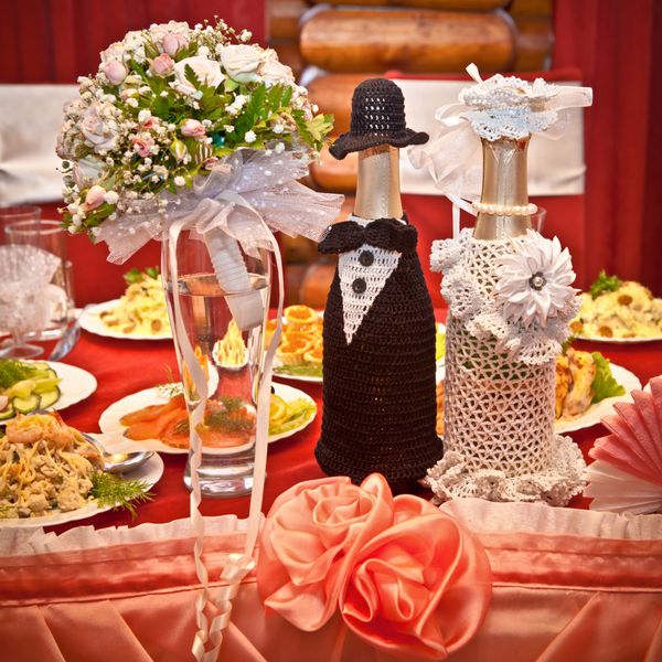 شامپاین عروسی و یک دسته گل روی میز تزئین شده