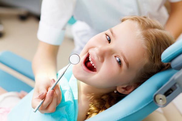 دختر کوچکی که به دندانپزشک مراجعه می کند