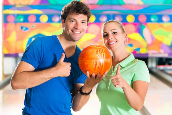 junge leute spielen bowling auf bowlingbahn