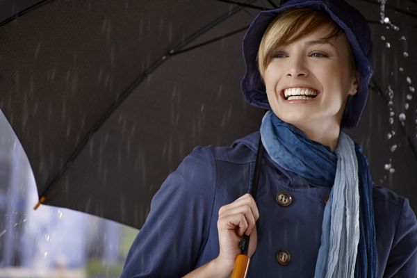 زن جوان با استفاده از چتر در باران