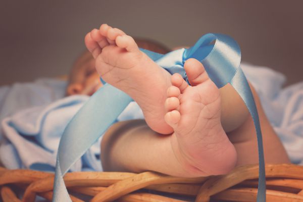 پاهای نوزادی که با روبان بسته شده اند