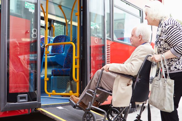 زوج سالمند سوار بر اتوبوس با استفاده از رمپ دسترسی ویلچر