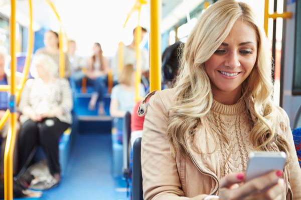 زن در حال خواندن پیامک در اتوبوس