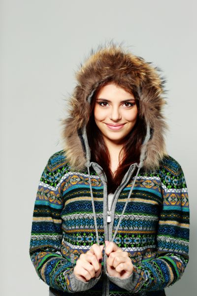 زن جوان خندان شاد با لباس گرم زمستانی