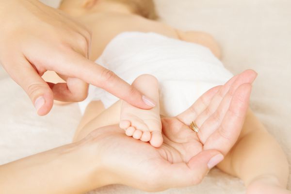 ماساژ پای نوزاد تازه متولد شده در دست مادر