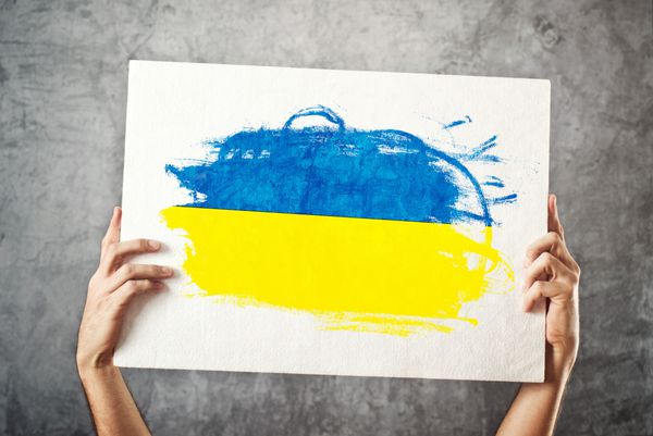 پرچم اوکراین مردی که بنری با پرچم اوکراین در دست دارد