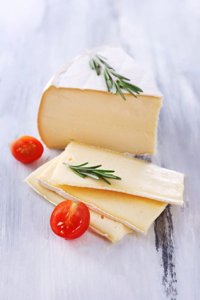 پنیر کمبرت خوشمزه با گوجه فرنگی و رزماری روی چوب
