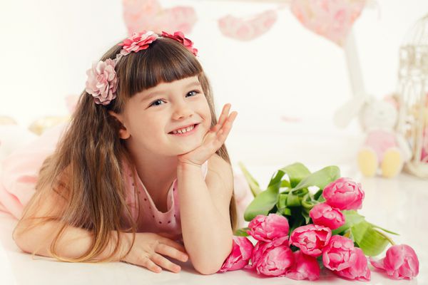 پرتره یک دختر کوچک زیبا با گل