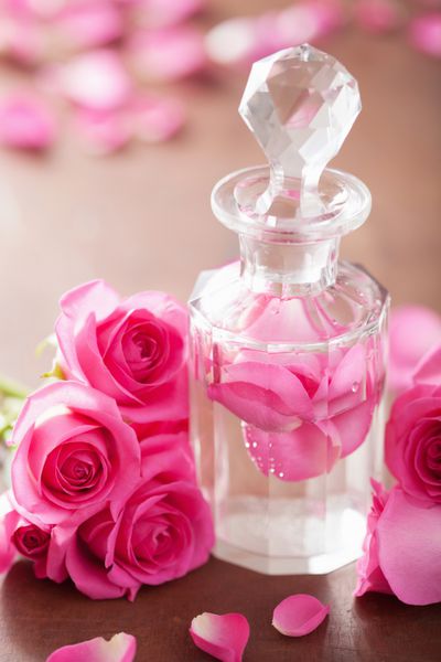 شیشه عطر و گل های رز صورتی رایحه درمانی آبگرم