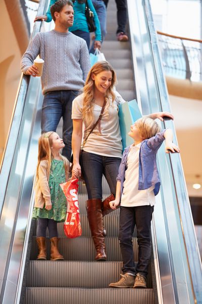 مادر و فرزندان در پله برقی در مرکز خرید
