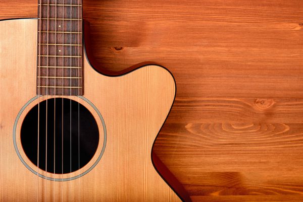 گیتار وسترن از نمای نزدیک در زمینه چوبی