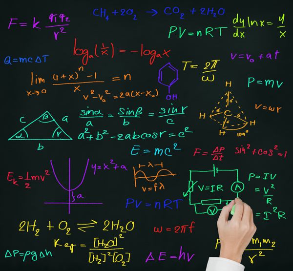 دست معلم که فرمول ریاضی و علوم دبیرستان را روی تخته سیاه می نویسد