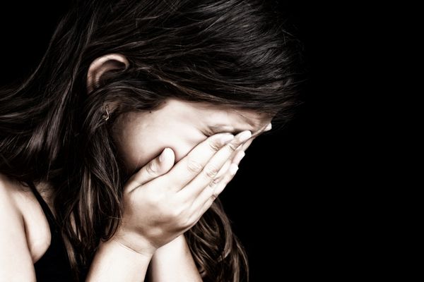 پرتره گرانج دراماتیک دختری در حال گریه کردن با دستانش روی f جدا شده روی پس‌زمینه سیاه