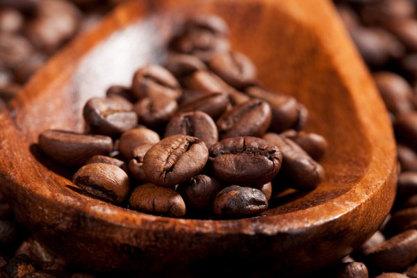 دانه های قهوه روی جزئیات قاشق چوبی پس زمینه قهوه مجلل به رنگ قهوه ای سبک روستیک