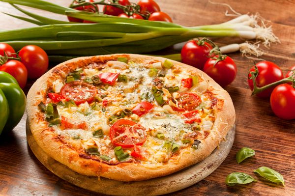 پیتزای تازه آماده پخته شده با گیاهان و سبزیجات