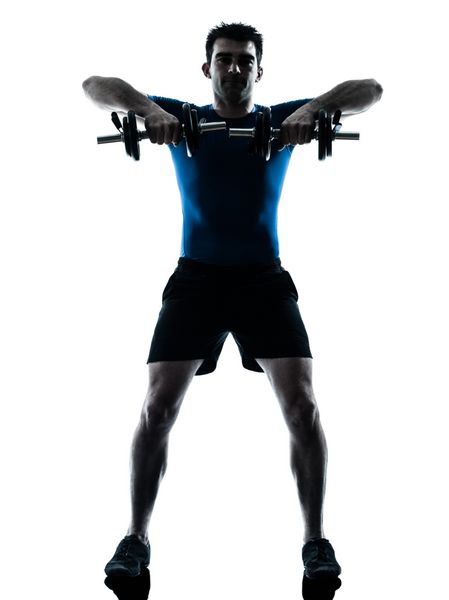 یک مرد قفقازی در حال انجام تمرینات ورزشی با وزنه در استودیوی silhouette جدا شده روی پس زمینه سفید
