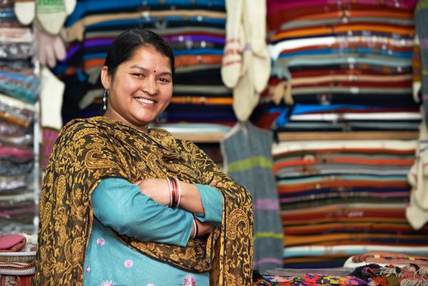 زن جوان هندی خندان بافنده در لباس مغازه شال