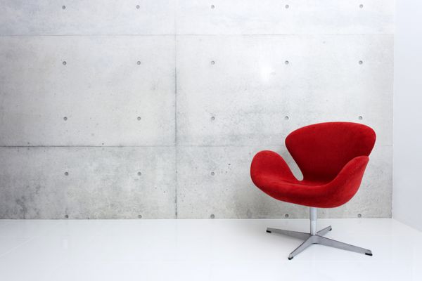 صندلی قرمز مدرن و دیوار بتنی