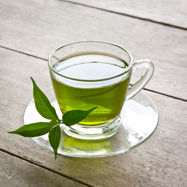 یک فنجان چای سبز روی تخته چوب برای سلامتی بنوشید