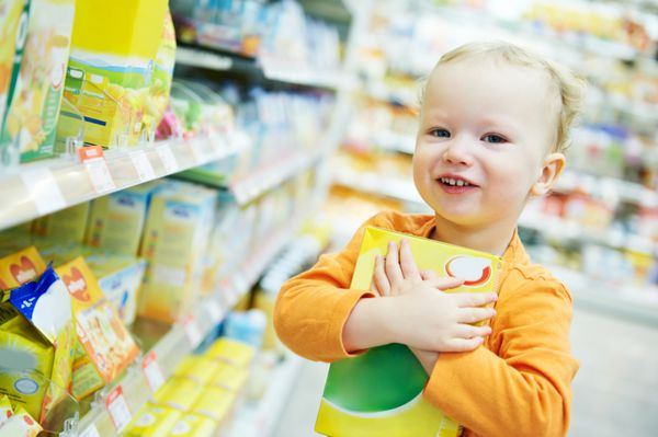 انتخاب یک کودک کوچک در حین خرید مواد غذایی در سوپرمارکت خواربارفروشی