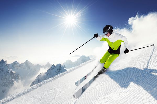 اسکی باز در کوهستان پیست آماده و روز آفتابی