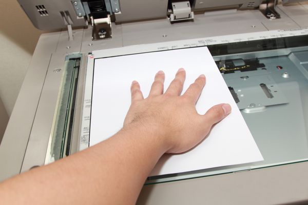 دست فشار دادن کاغذ روی دستگاه کپی