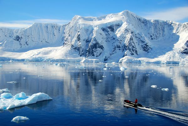قایق کوتوله شده توسط کوه های قطب جنوب